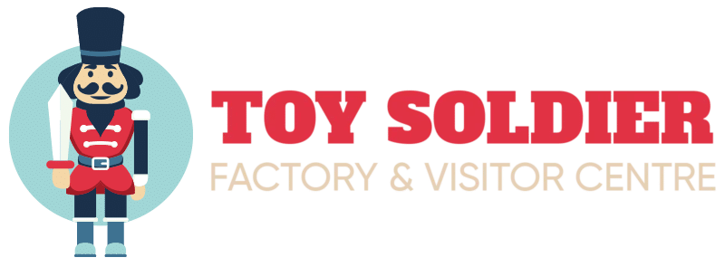 Logo of Toy Soldier Factory & Visitor Centre featuring a graphic of a smiling toy soldier in traditional uniform next to the red and black text of the company's name.