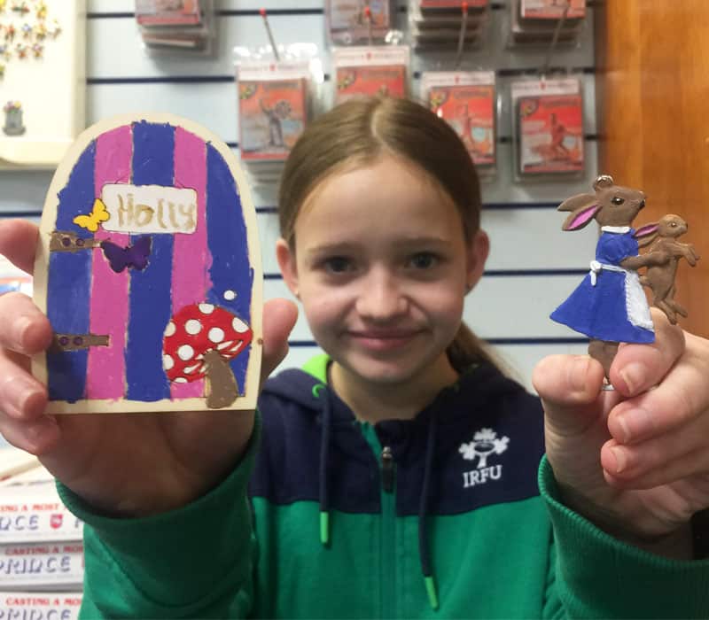 Easter image of young girl with fairy door and bunny that she painted during workshops